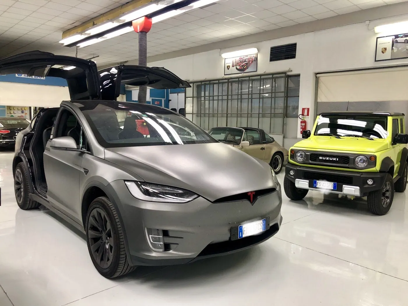 Una Tesla Model X grigia con le porte ad ala aperte