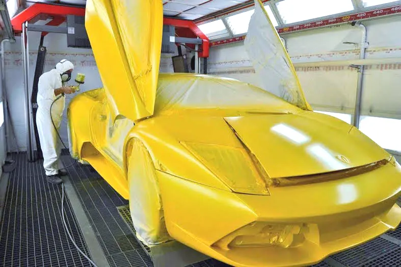 Una Lamborghini gialla in cabina di verniciatura